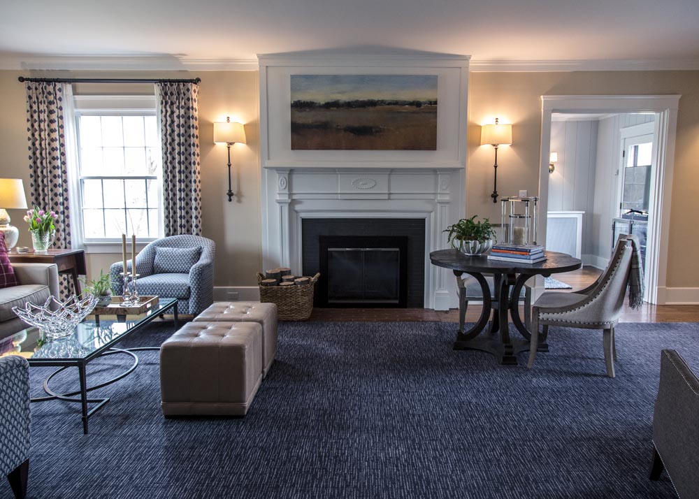 Blue rug in living room with hearth framed by scones