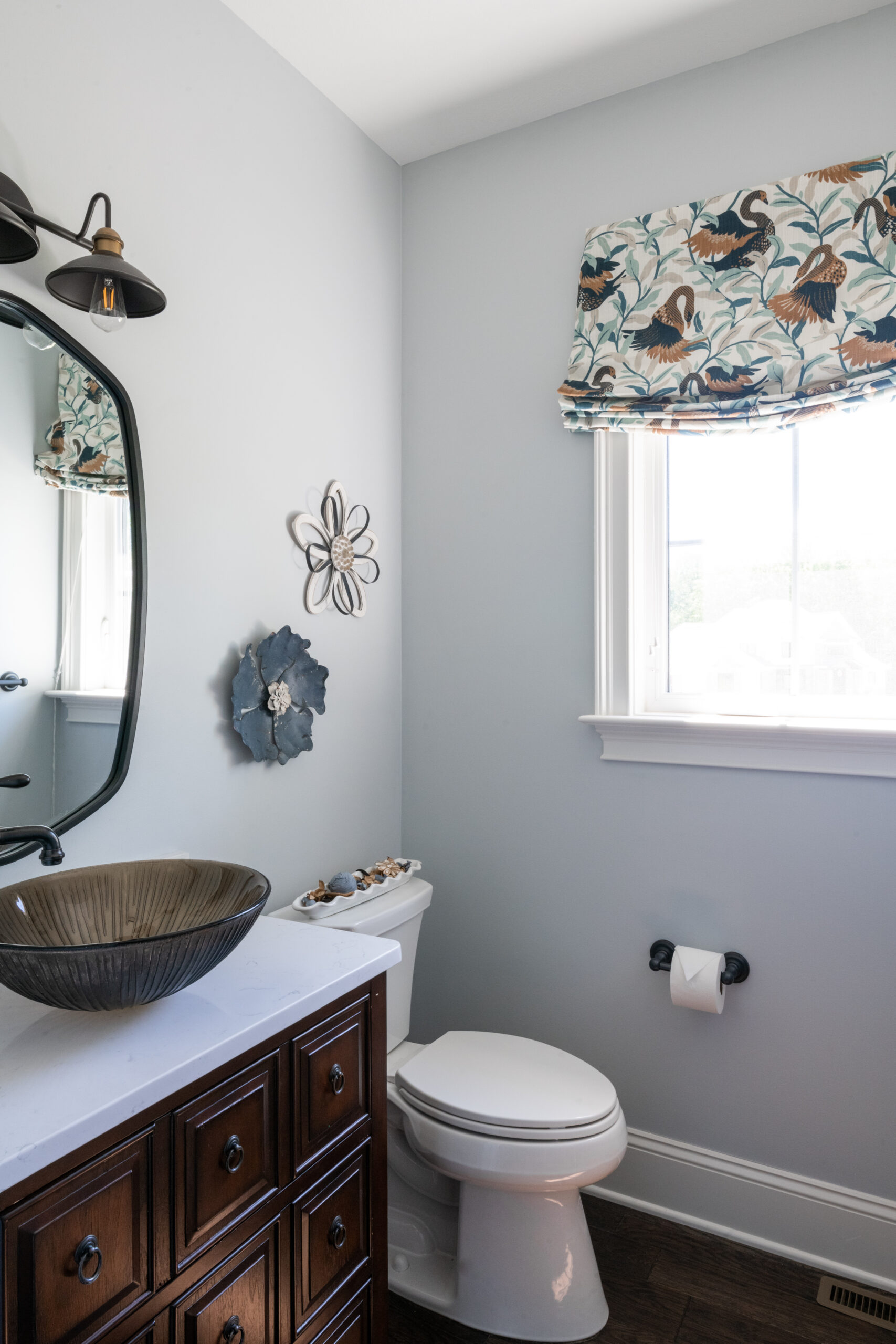 powder room with vessel sink and colorful roman shade
