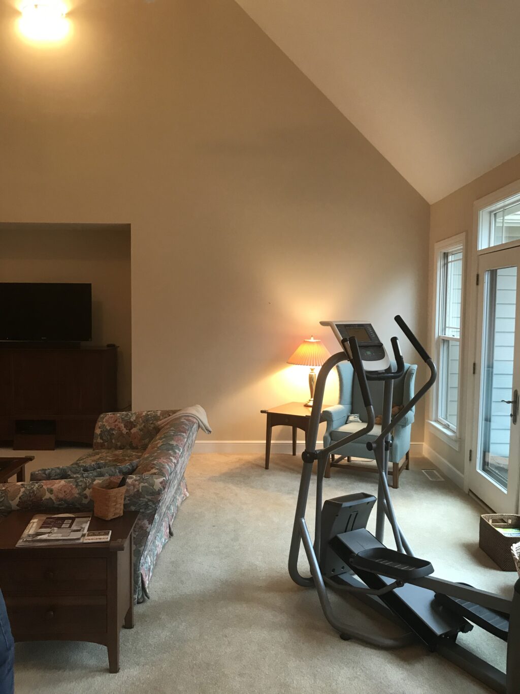 Living room with couch, arm chair, and exercise stepper