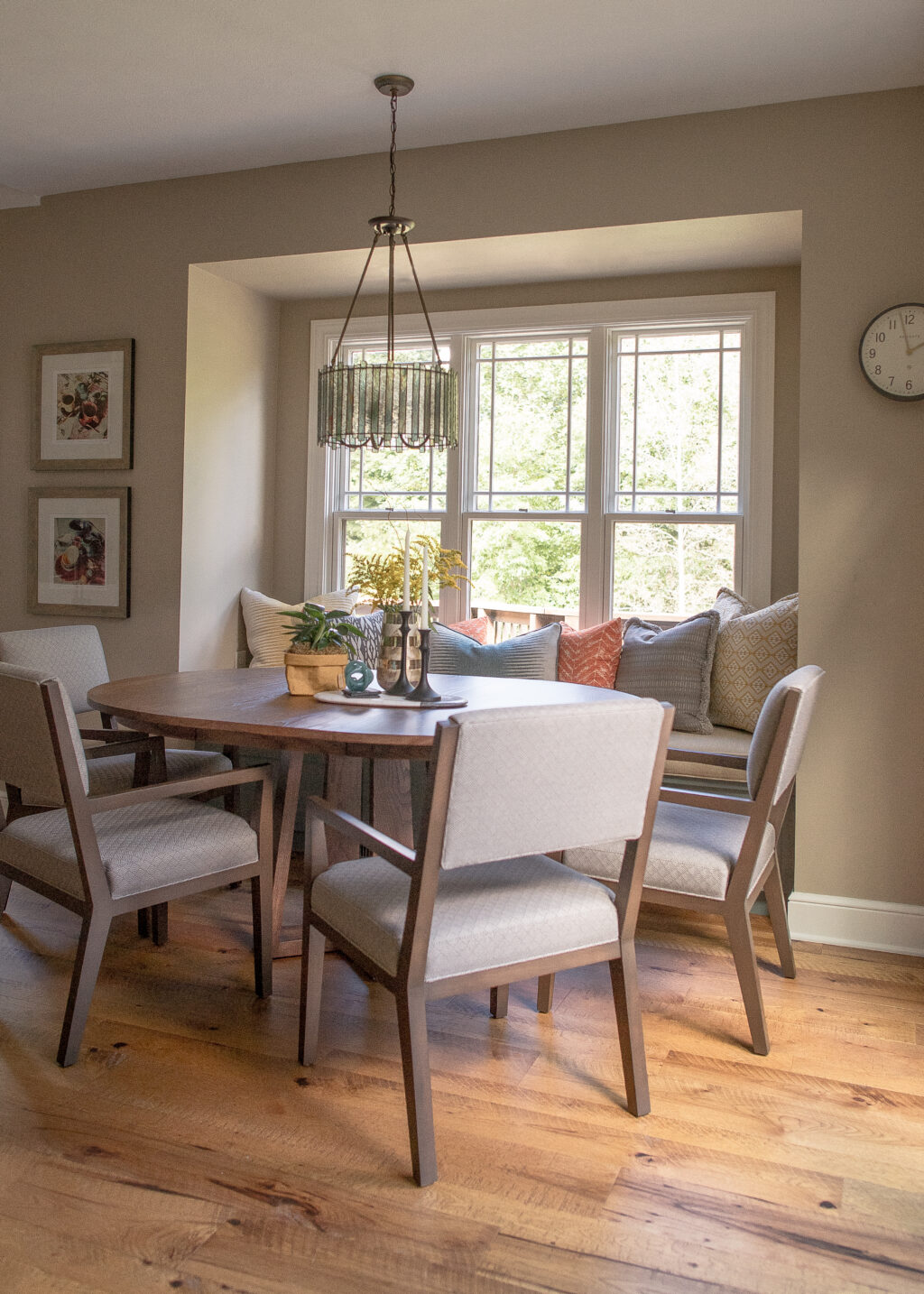Kitchen Dining Nook Kitchen nook with round table, modern gray/wood chairs, and window seat with orange and blue pillows