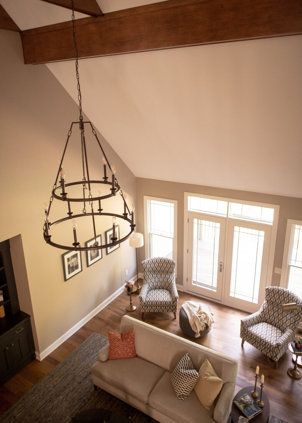Bird's eye of a living room with black chandelier, couch, and two arm chairs