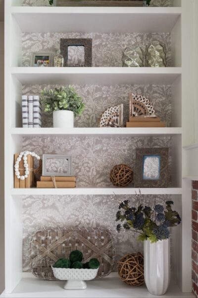 Shelves with frames and wallpaper background.