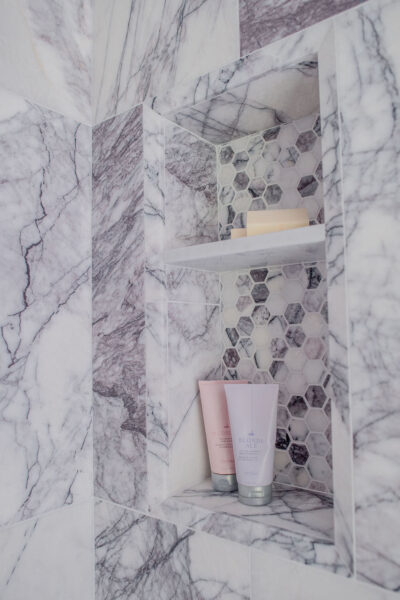 Purple tile inset in shower with shampoo and soap Purple tile inset in shower with shampoo and soap