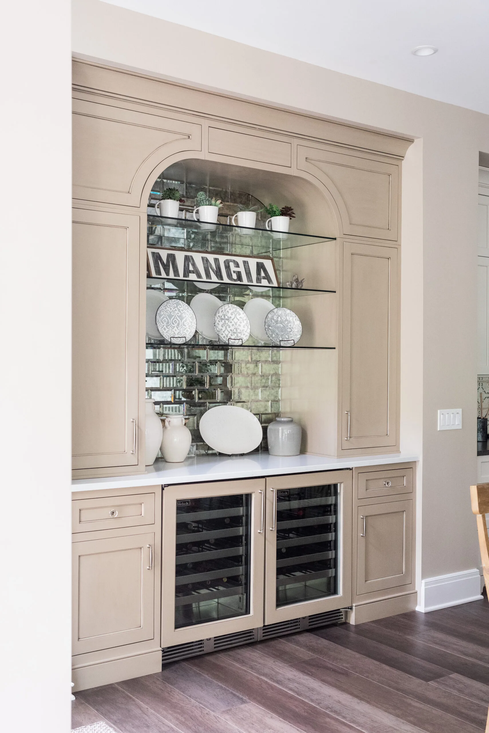 Painted coffee bar in taupe color with mirror backsplash and glass shelves for display