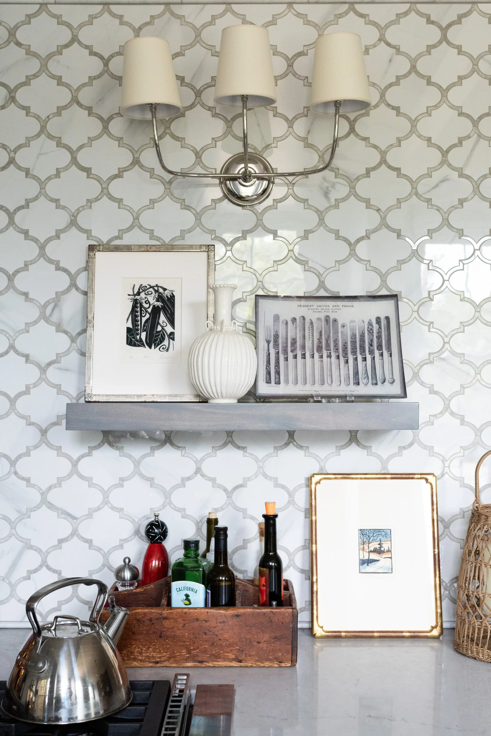 arabesque marble mosaic backsplash and floating shelf for collected vintage art and kitchen tools