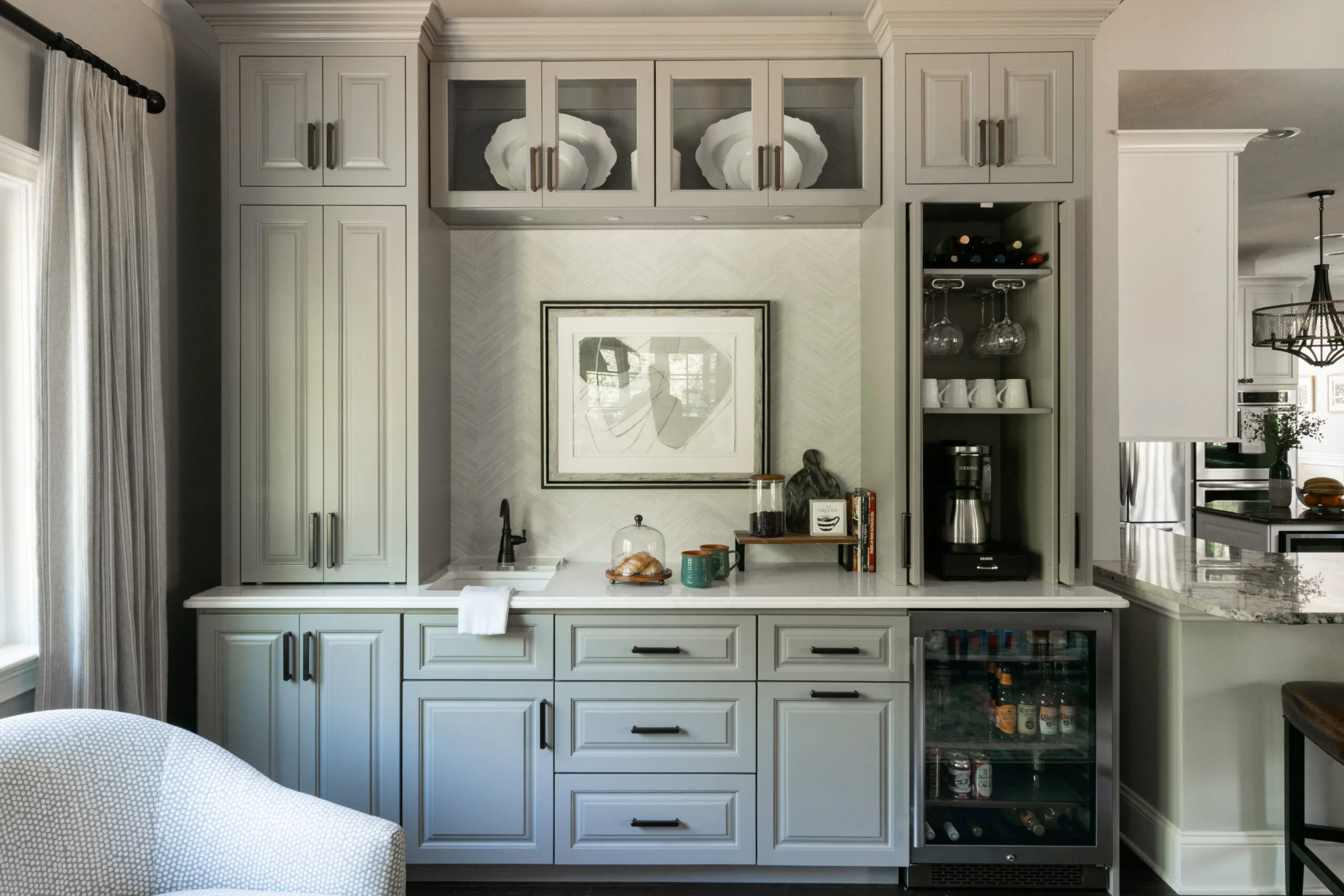 Wet bar with traditional gray cabinets, drinkware, and a stainless steel mini fridge