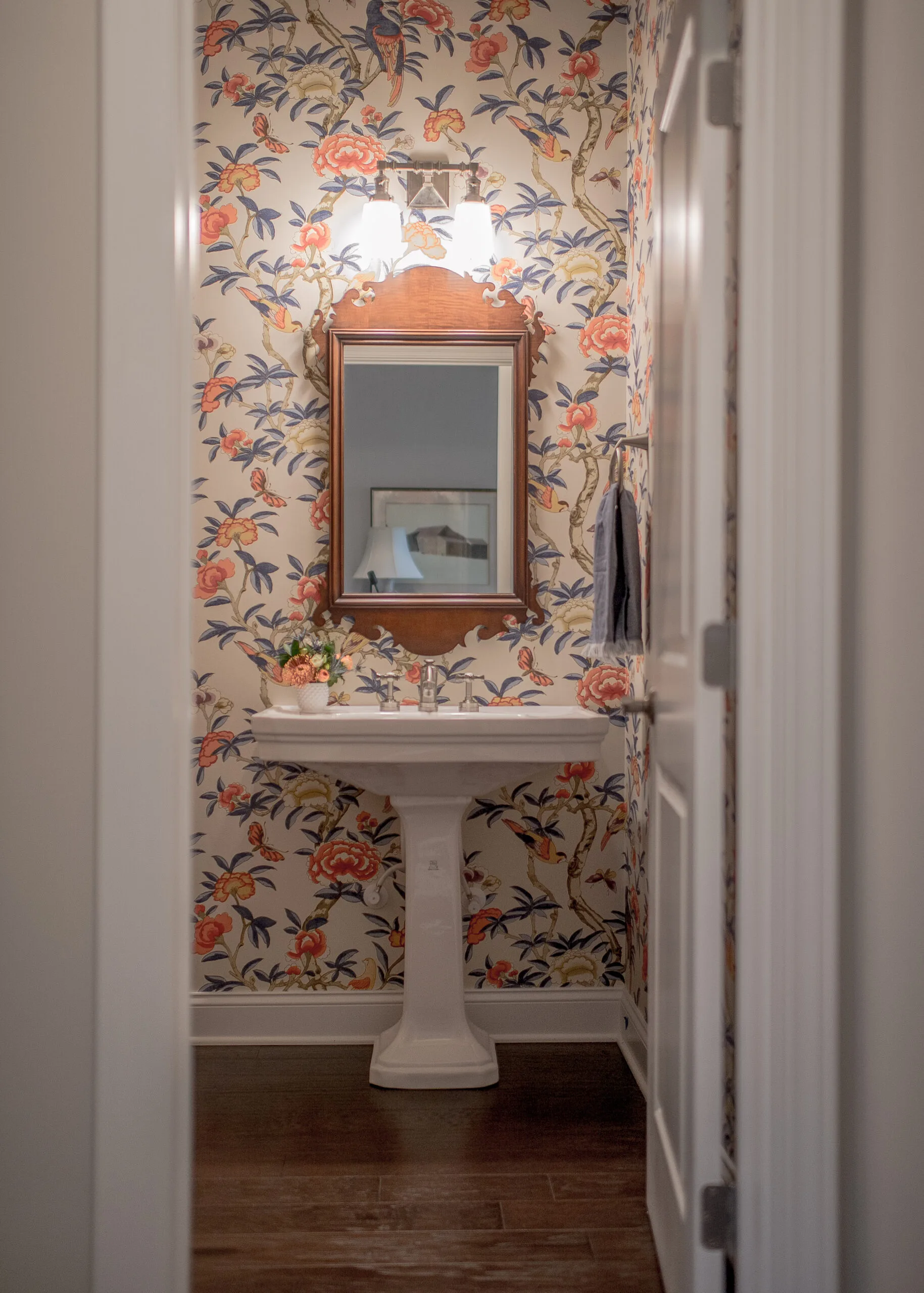 view into half bathroom with wallpapered walls