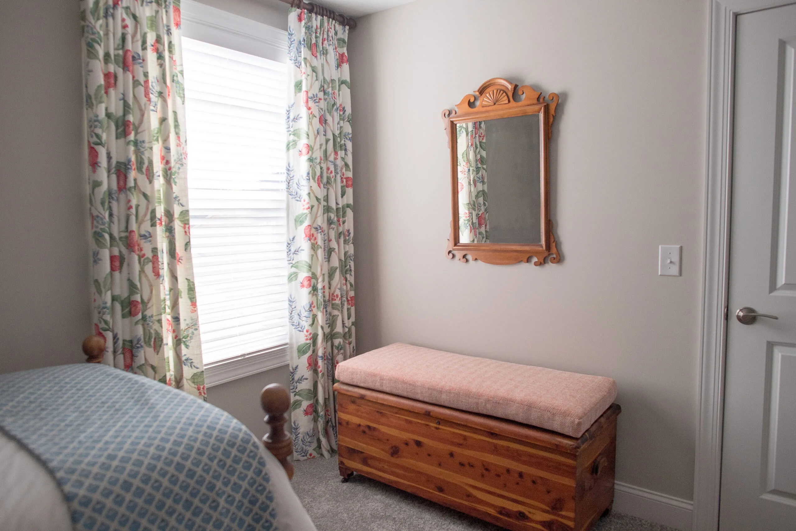 drapery on guest bedroom window with bench seat nearby