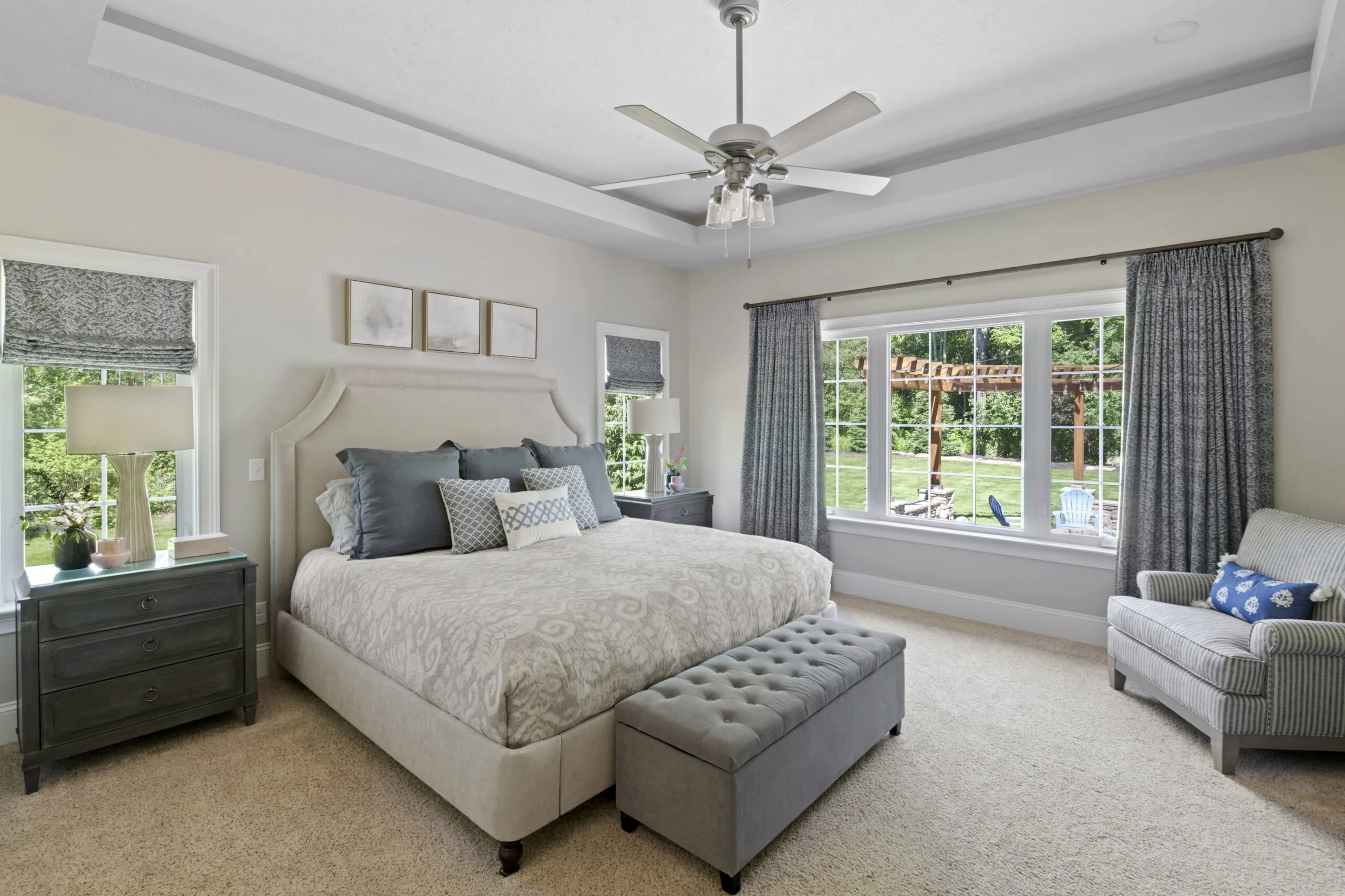 Bedroom with gray / blue accent colors within bedding, nightstands, and curtains.