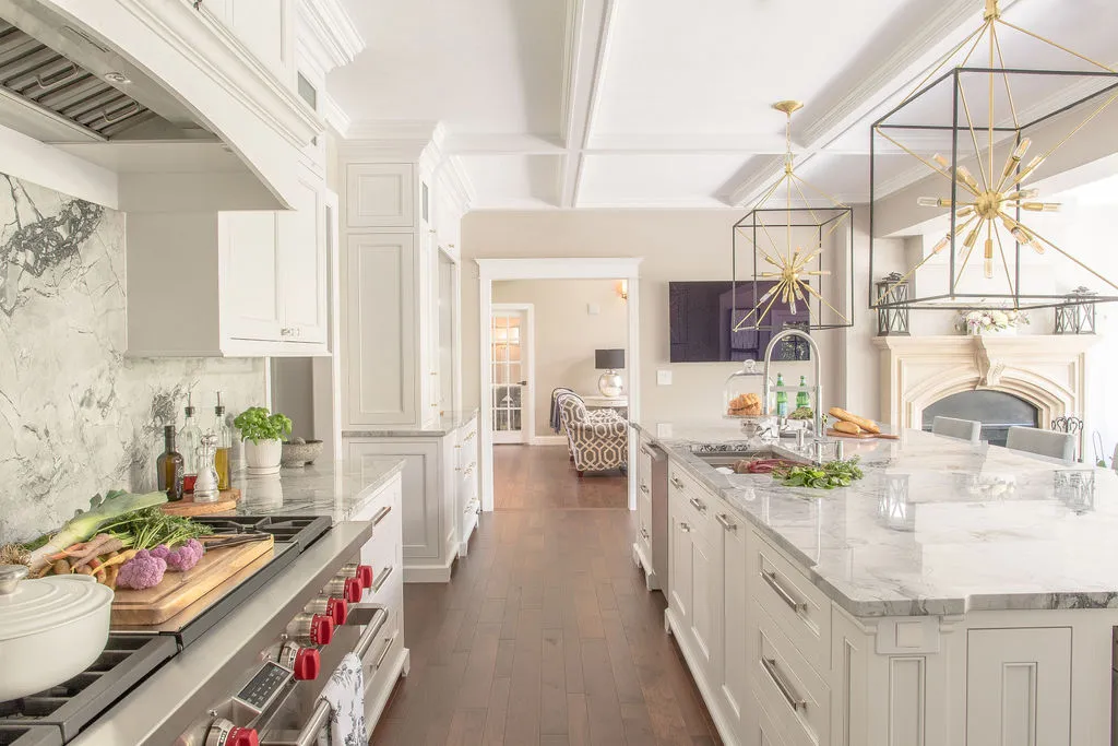 Image of a neutral, traditional kitchen with light gray countertops and large square pendants