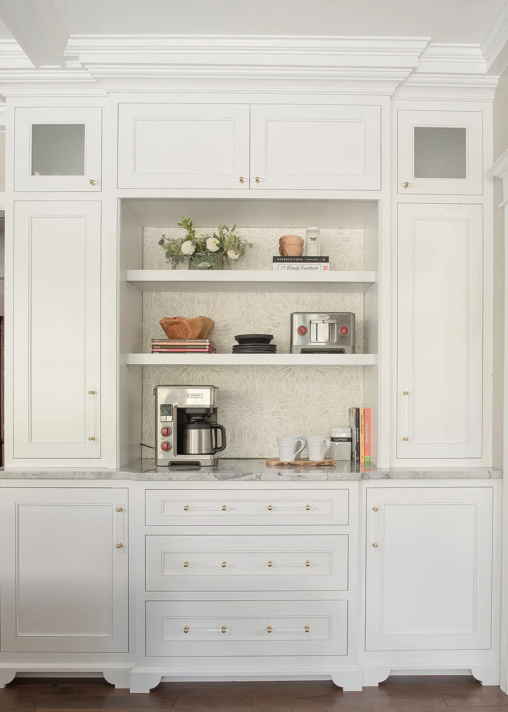 Full height, white cabinetry with open shelves in the middle with kitchen appliances