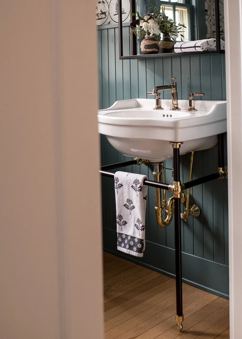 guest bathroom featuring a pedestal sink and dark green walls