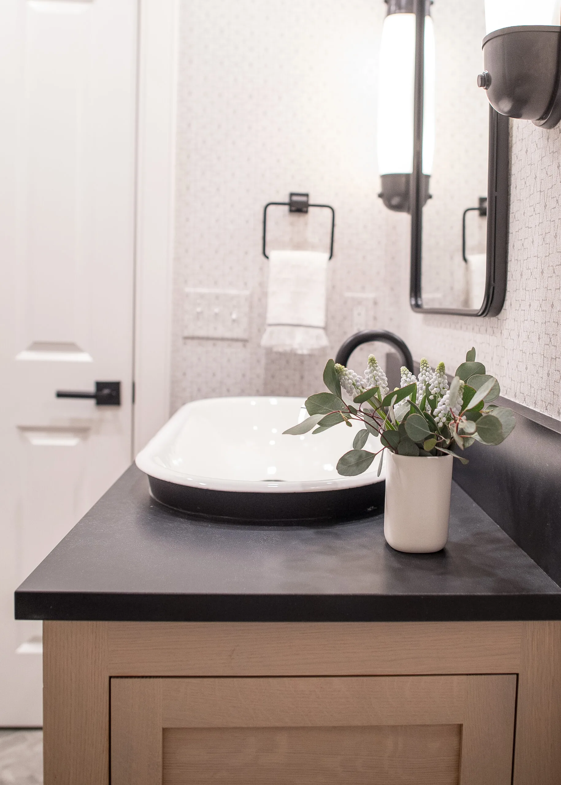 Close up on a vanity sink from the side with a towel holder in the background