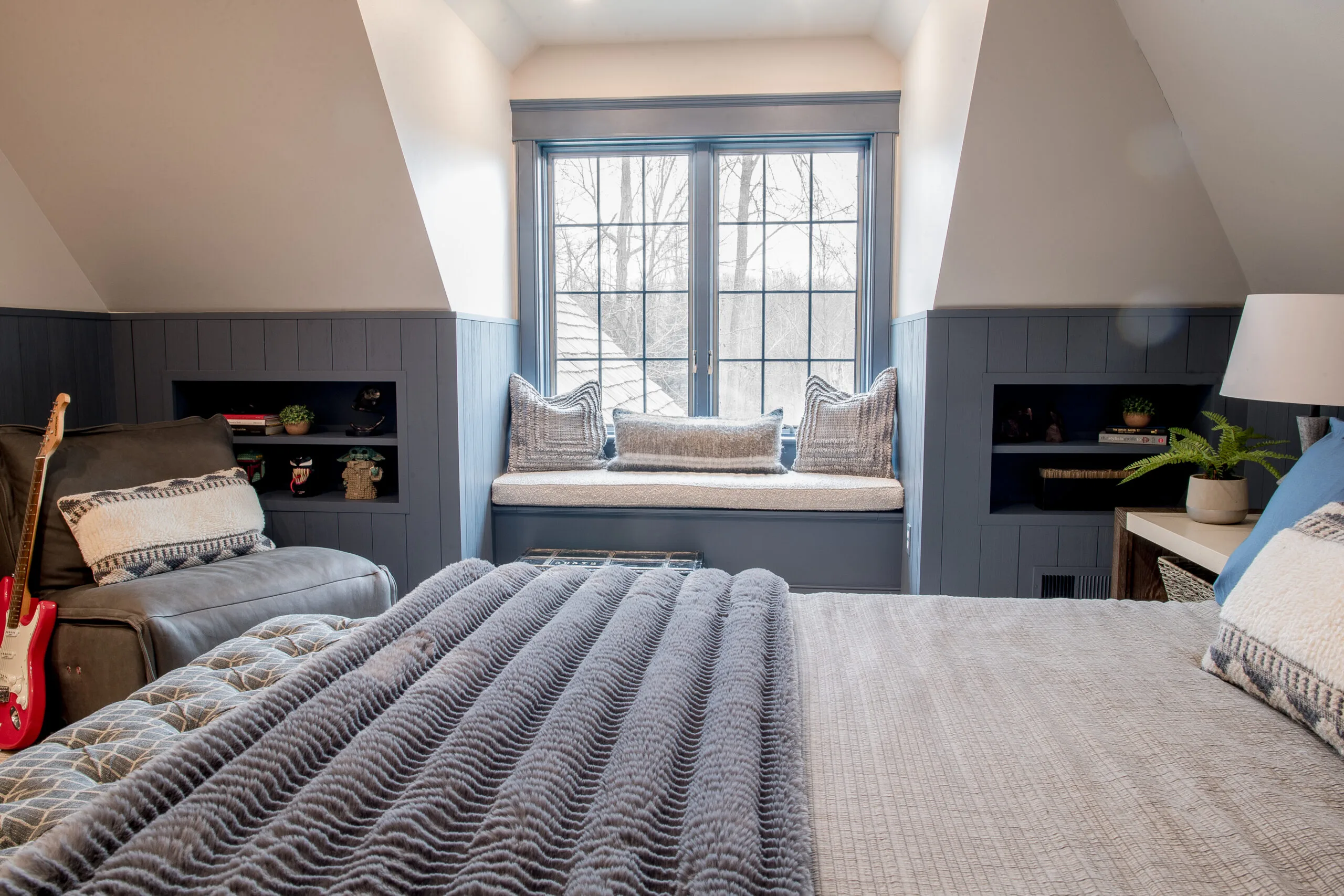 Image in a bedroom looking at a window bench with a cushion and pillows