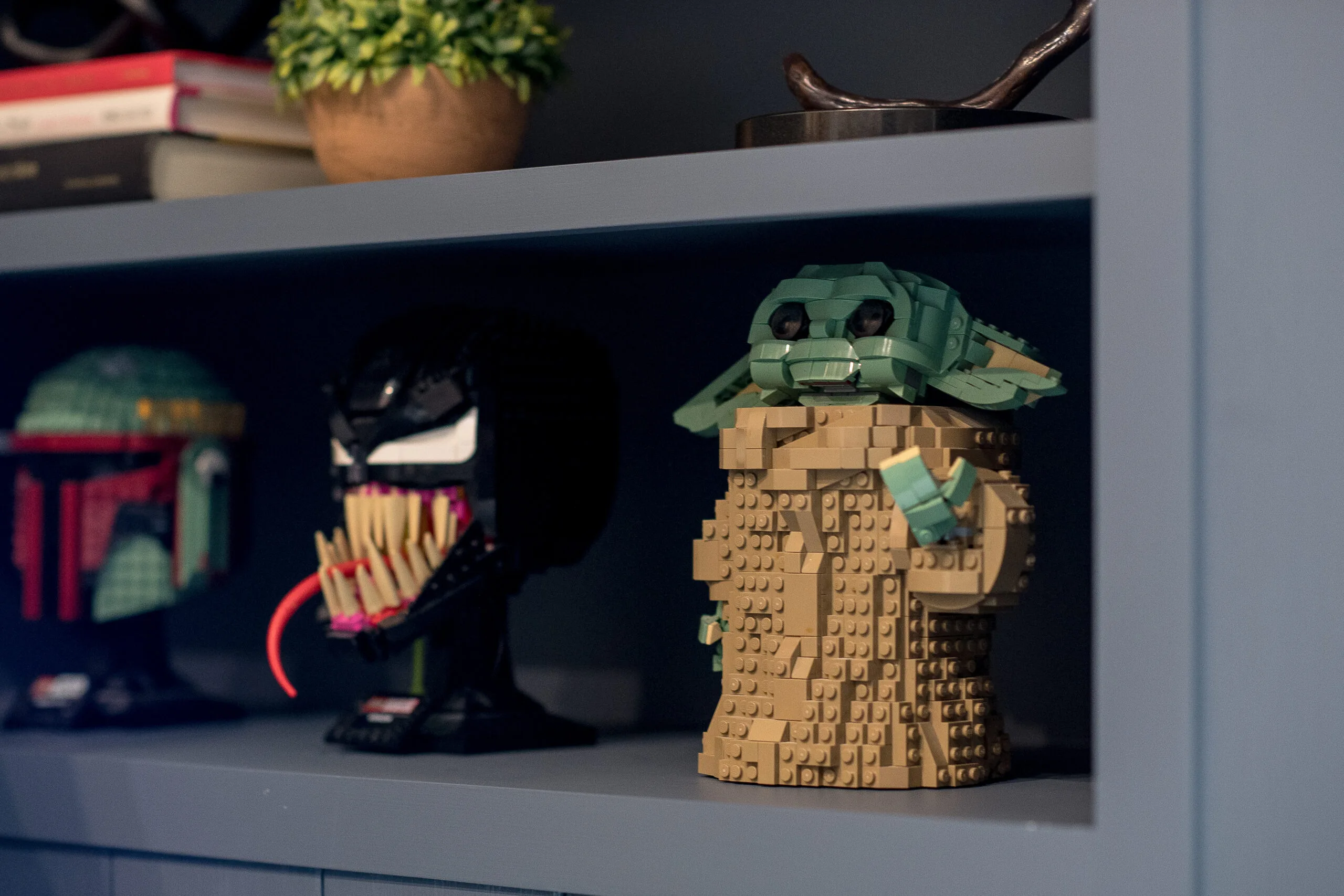 Close up image of blue open shelving with star war figures, books, and a succulent