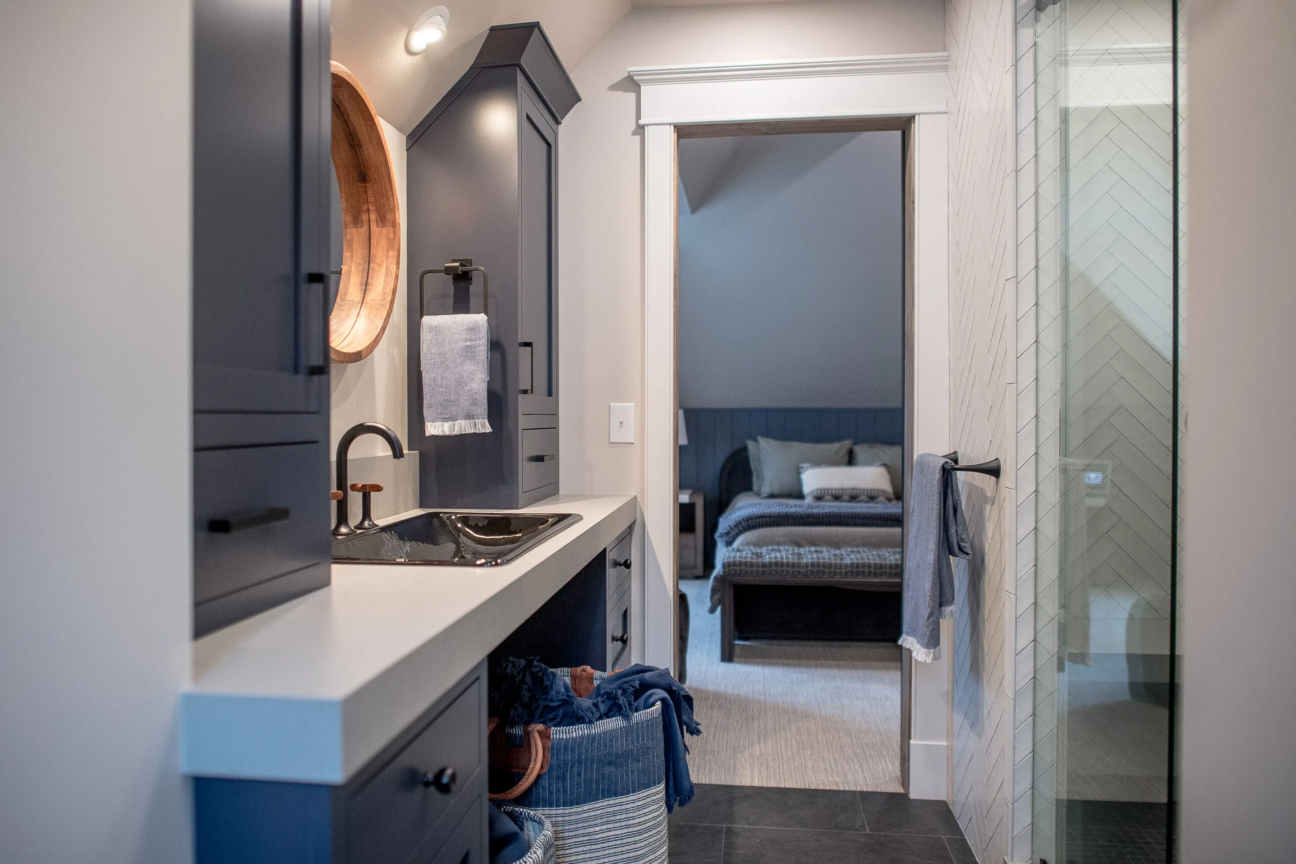 Image of a navy blue and neutral bathroom looking in to a bedroom of similar colors
