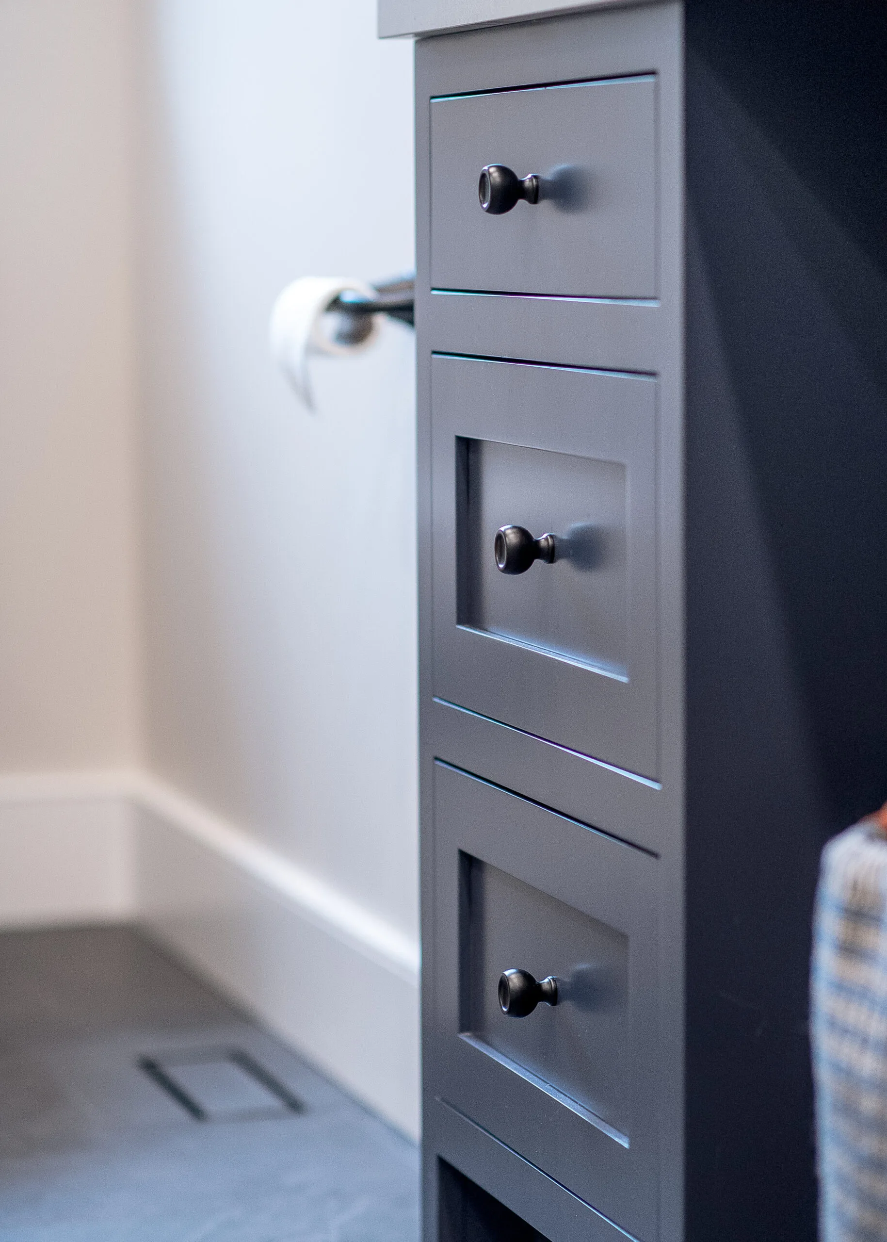 Close up image of blue base cabinet drawers with black knobs