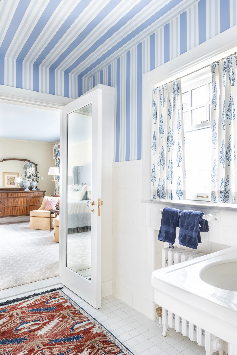 Blue and white striped bathroom with red oriental rug