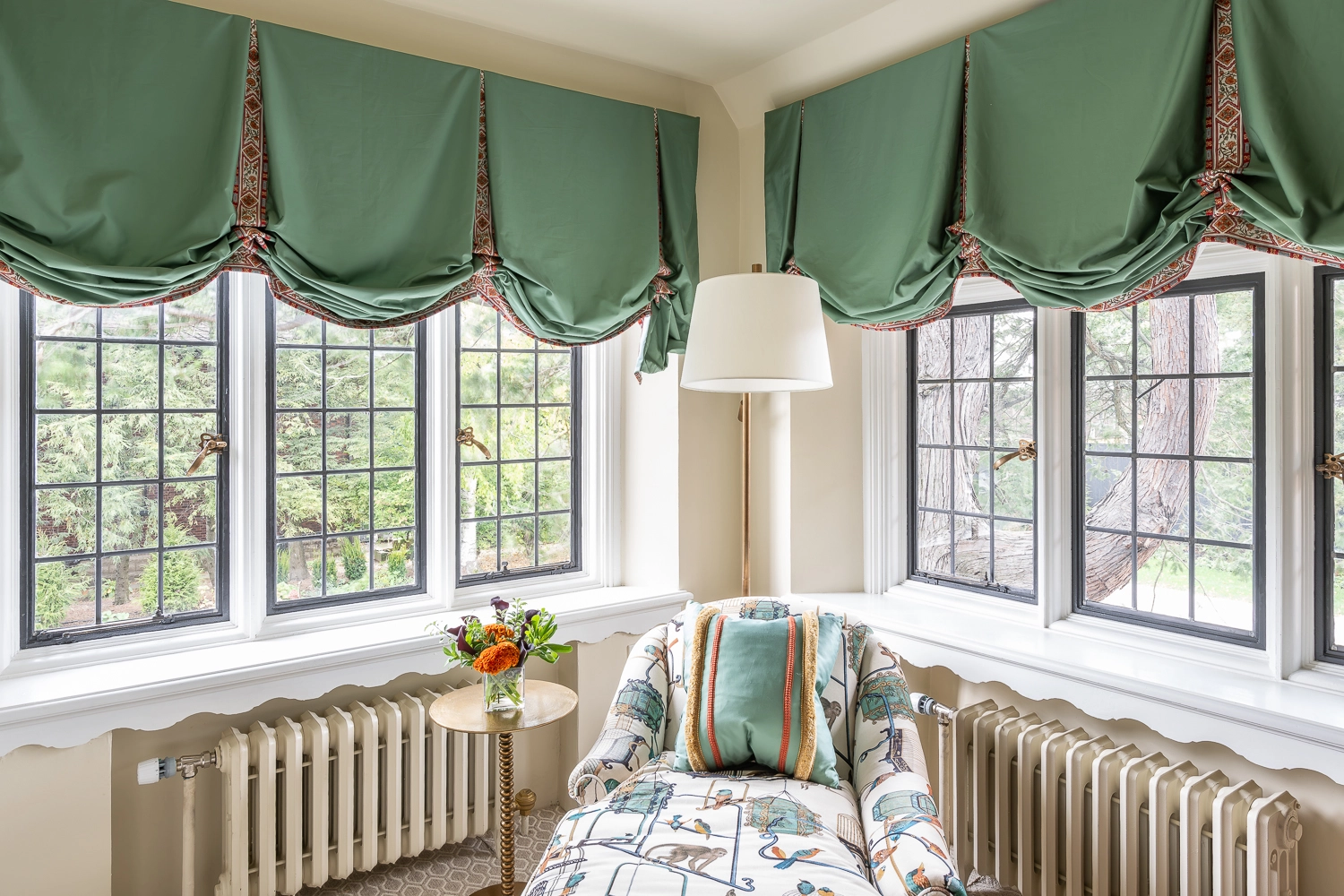 Image of a chaise lounge in front of windows with a side table and florals