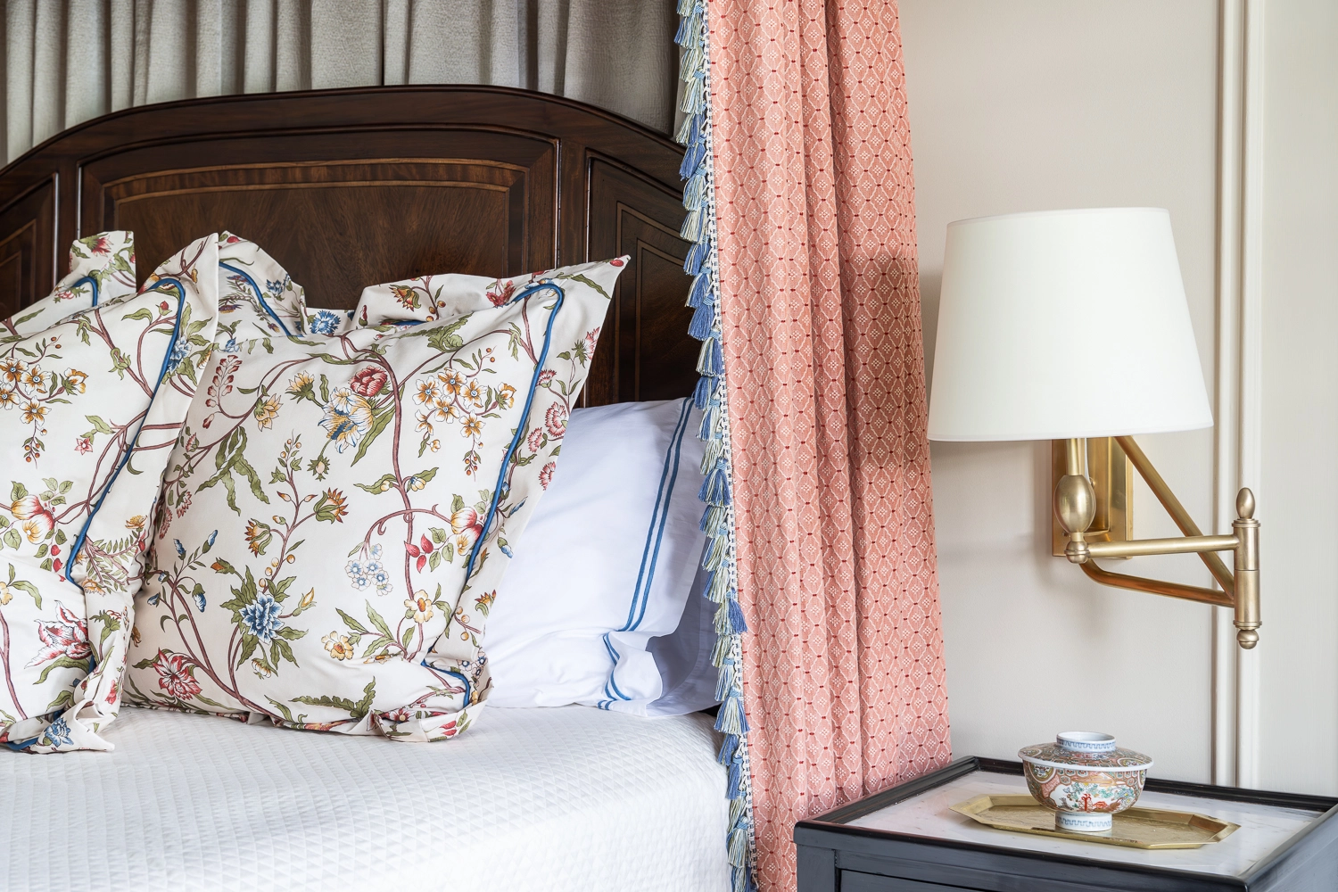 Canopy bed image focusing on decorative sham pillows and the wooden headboard