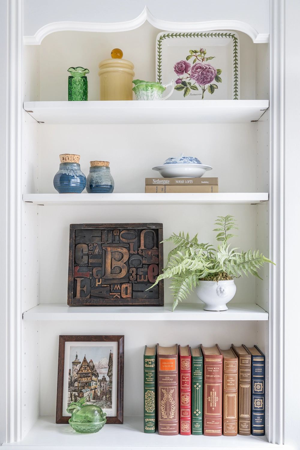 White bookcase with green accessories and books