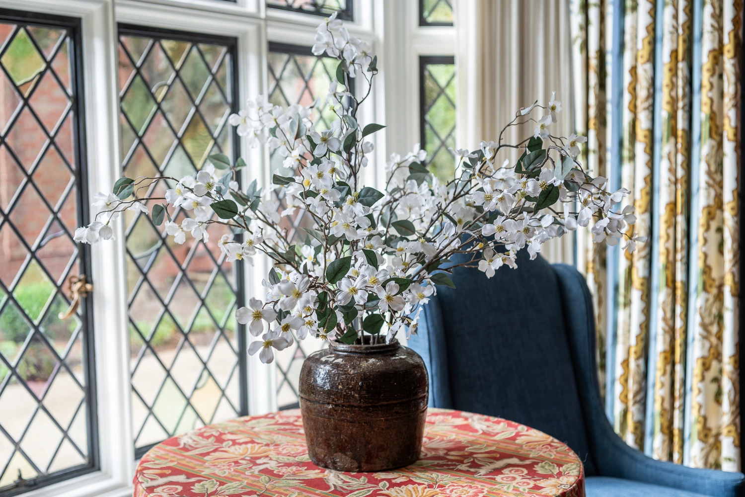 Image of floral arrangement on table in front of glass window