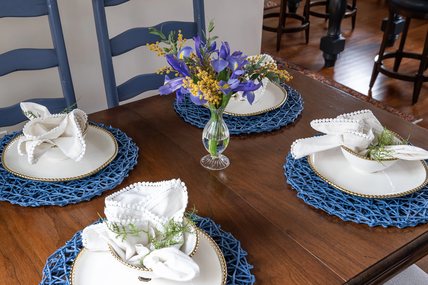 Image from above a wooden kitchen table with placemats and silverware