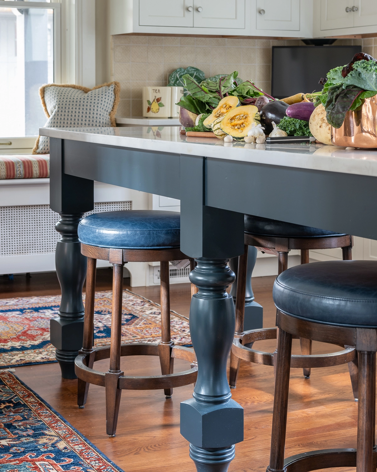 Image of a kitchen island with round blue stools tucked under