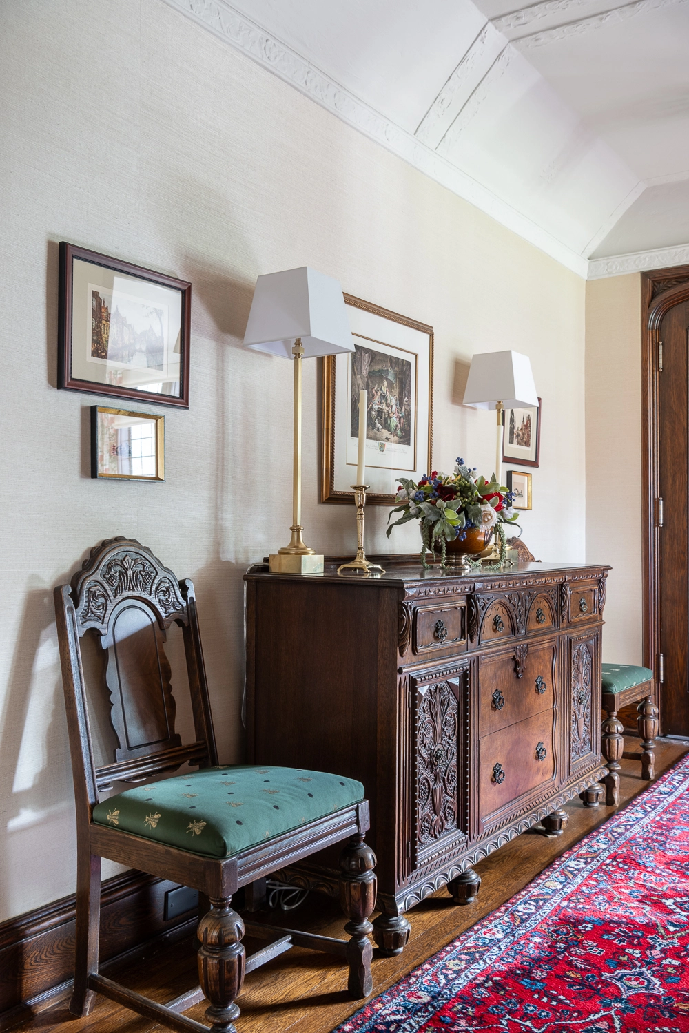 Image of a hallway with a wooden chest beside a chair and artwork above