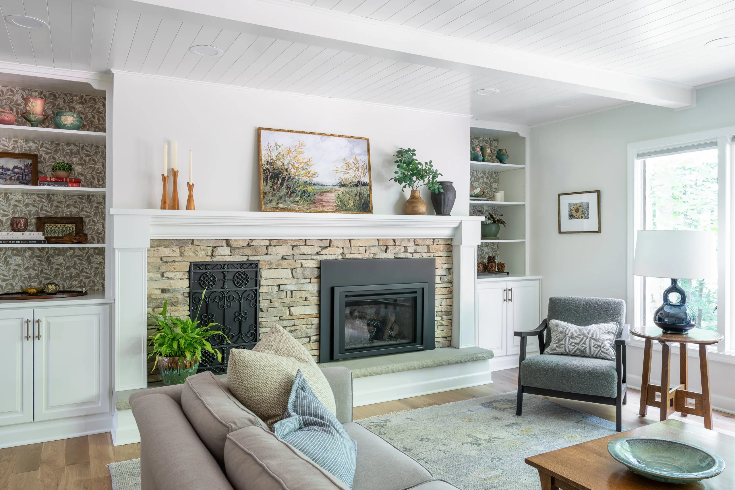 cozy living room with layered artwork and stone fireplace