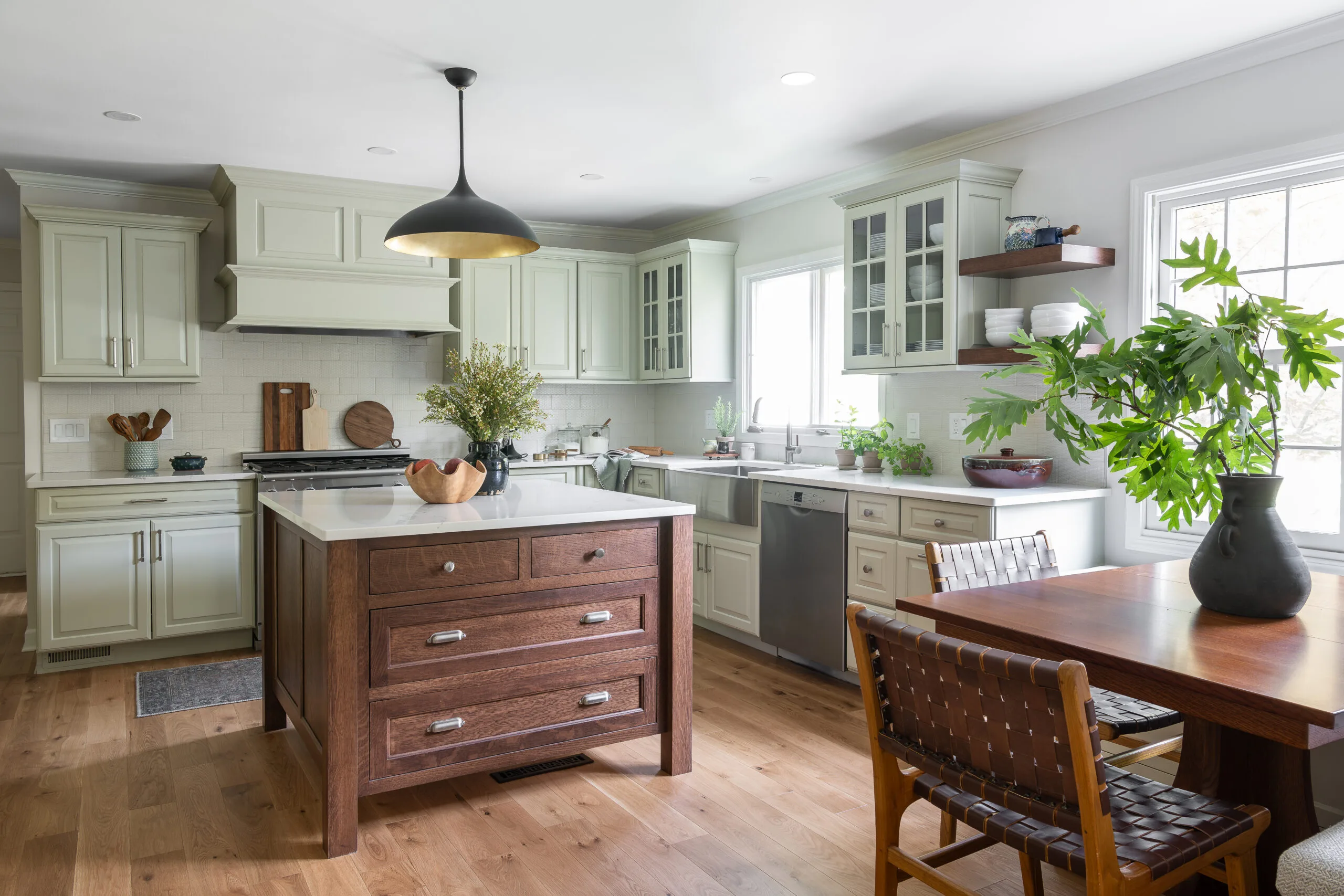 Craftsman style island in cozy kitchen with painted light green cabinets