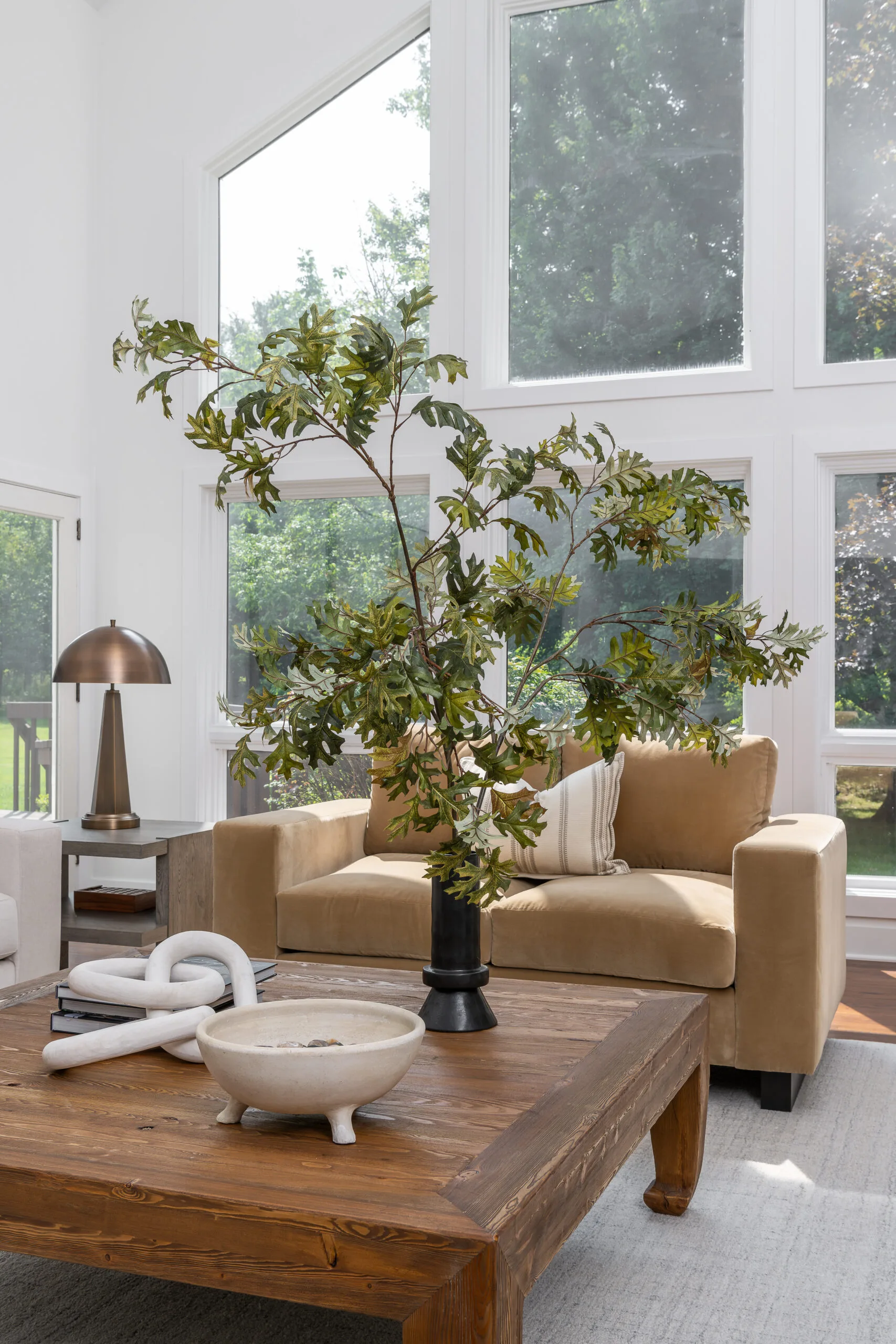 2 story living room with 2 custom sofas and large center coffee table and natrual branch arrangement