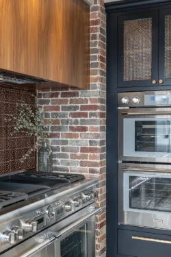 Kitchen corner with double ovens and brick accent wall