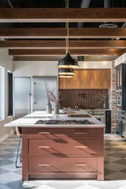 Modern kitchen with marble countertops and brick red island