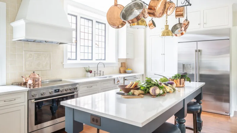 open kitchen space with center island and copper pots hanging from above
