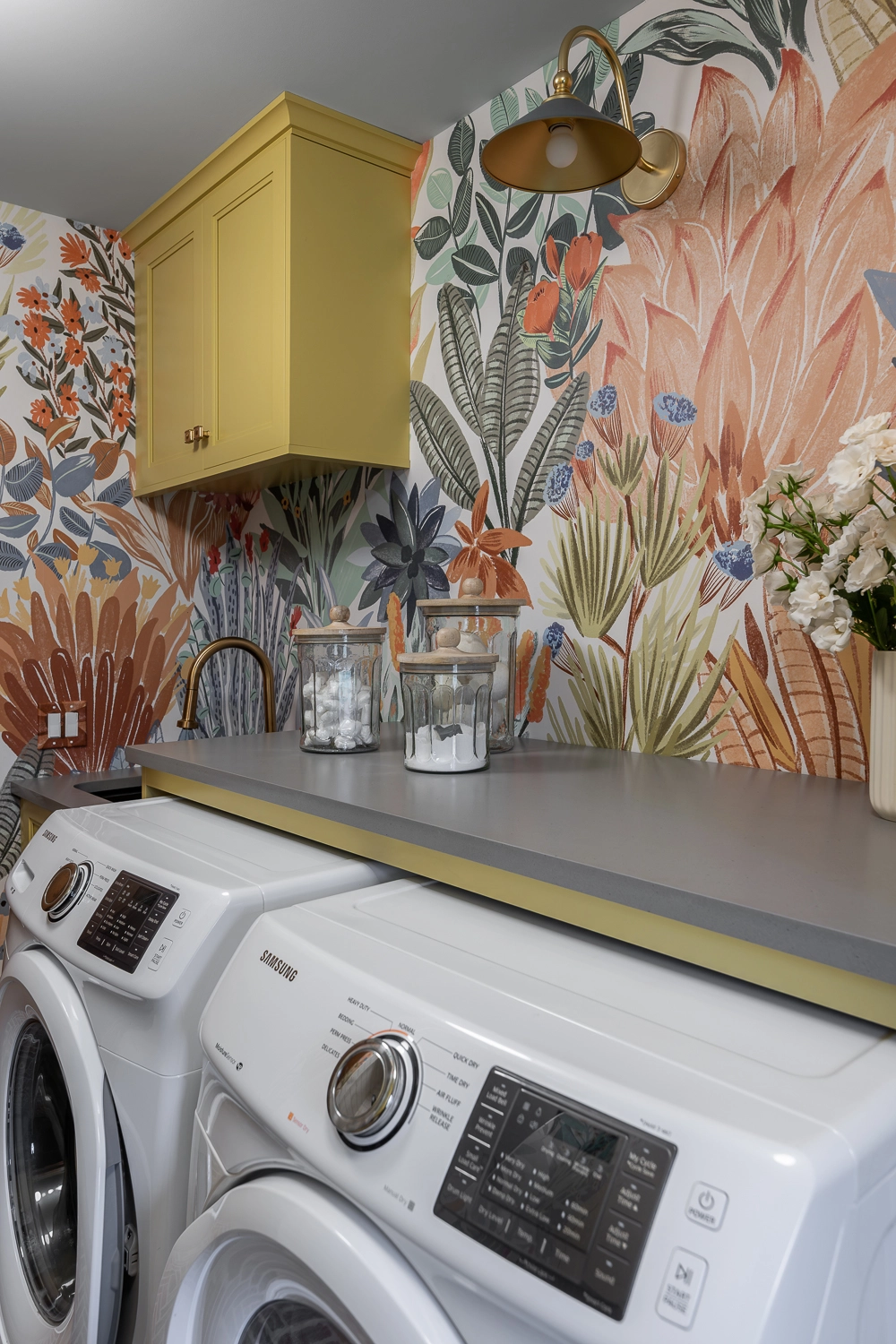 laundry room with bright wallpaper and yellow cabinetry