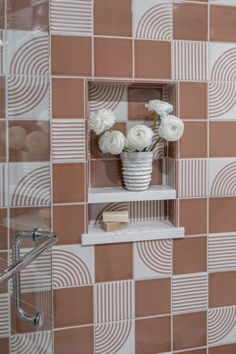 image of coral modern tile in shower with playful floral arrangement in the shower niche