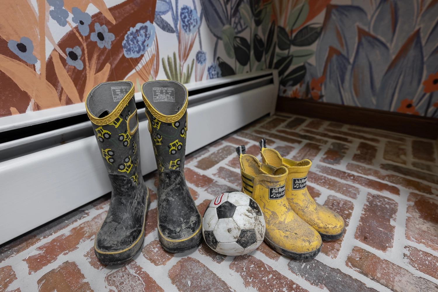 laundry room and mudroom with brick floor and cute kids muddy boots and soccer ball