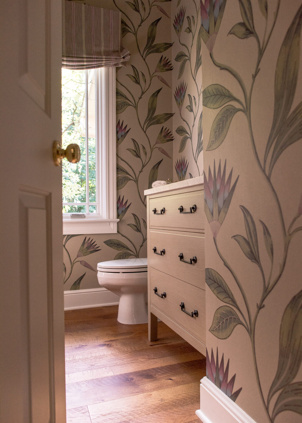 Powder room with Orchid wallpaper and cream colored vanity